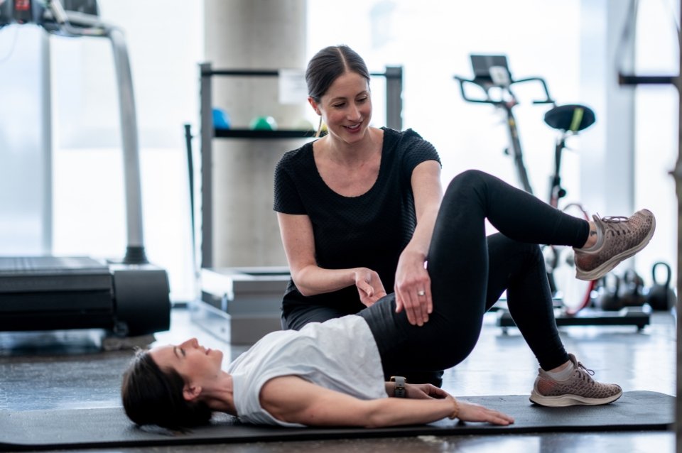 Physiotherapist helping woman with pelvic floor exercises at the gym